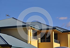 Upper storey of rendered house with metal roof