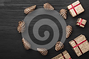 Upper, top view, of Christmas presents on a wooden black rustic background, with space for text writing.