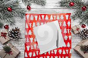 Upper, top view, of Christmas presents on a wooden rustic background, decorated with evergreen branch.