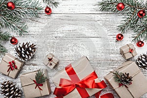 Upper, top view, of Christmas presents on a wooden rustic background, decorated with evergreen branch.