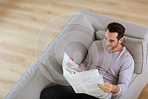 Man in sofa reading news