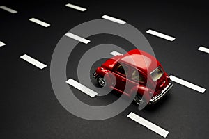 Upper view of  Red toy car on a road with road lanes