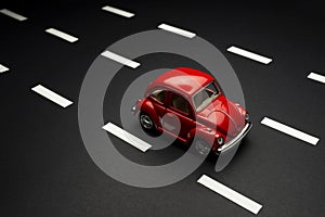 Upper view of  Red toy car on a road with road lanes