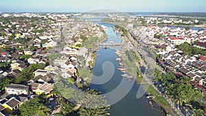 Upper view town separated by calm river reflecting blue sky