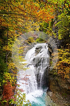 Upright photography of Cascada Del Estrecho  Estrecho waterfall during Autumn season,, in Ordesa valley  Heusca, Spain photo