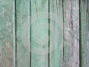 Upright striped wooden wall, fence, background with old threadbare green paint