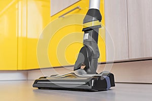 Upright vacuum cleaner brush on the laminate floor close-up.