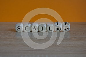 Upscale or downscale symbol. Concept words Upscale or Downscale on wooden cubes. Beautiful orange background. Business upscale or