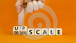 Upscale or downscale symbol. Concept words Upscale or Downscale on wooden cubes. Beautiful orange table orange background.