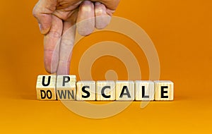 Upscale or downscale symbol. Concept words Upscale or Downscale on wooden cubes. Beautiful orange table orange background.