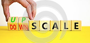 Upscale or downscale symbol. Concept words Upscale or Downscale on wooden cubes. Beautiful yellow table white background.