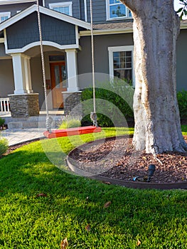 Upscale home with shaded front yard and swing photo