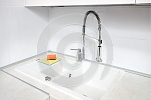 Upscale kitchen Ultimate Gray interior with Illuminating yellow sponge for washing dishes. Faucet mixer and stone sink