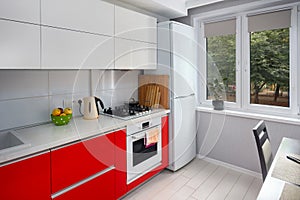 Upscale Maple Red and Smoky White kitchen in luxury home with stoneware countertop flat wooden panels design with window