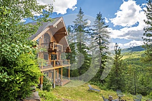 An upscale rural log home on a hillside in the mountains near Sandpoint, Idaho, USA, during summer