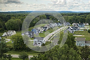 Upscale suburban homes with large backyards and green grassy lawns in summer season. Private residential houses in rural