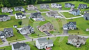Upscale suburban homes with large backyards and green grassy lawns in summer season. Private residential houses in rural
