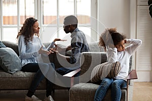 Upset african daughter closing ears while parents fighting at ho