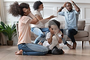 Upset african kids closing ears hurt by parents fighting photo