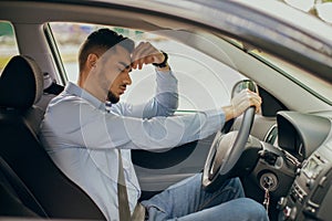 Upset arab businessman driver touching his head, stuck in traffic