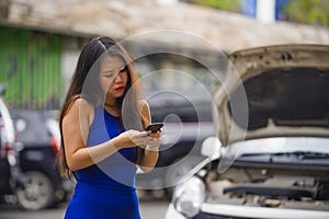 Upset Asian Chinese woman in stress stranded on street suffering car engine failure having mechanic problem calling on mobile