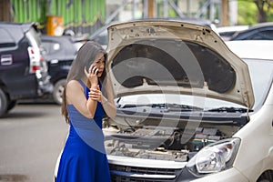 Upset Asian Japanese woman in stress stranded on street suffering car engine failure having mechanic problem calling on mobile