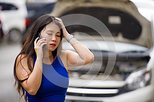 Upset Asian Korean woman in stress stranded on street suffering car engine failure having mechanic problem calling on mobile phone