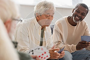 Upset asian man playing cards with