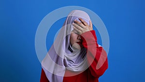 Upset Asian muslim woman shows regret expression, disappointed gesture