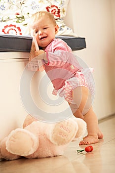 Upset Baby Girl Learning To Stand Up At Home