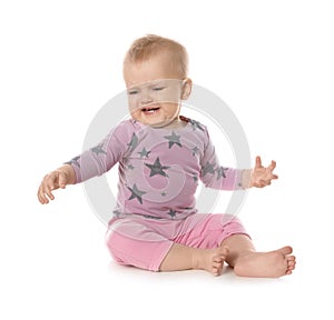 Upset baby girl sitting on white