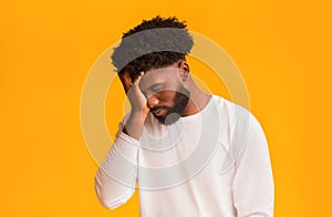 Upset black guy covering his face with hand