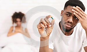 Upset black guy taking potency pill before sex with girlfriend