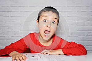 Upset boring schoolboy doing homework. Education, school, learning difficulties concept