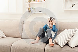 Upset boy with digital tablet at home