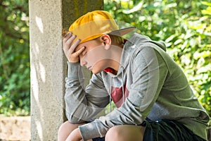 Upset Boy Sitting In Park