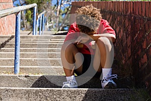 Upset boy sitting on staircase in the boot camp