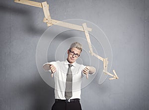 Upset businessman in front of descending graph.