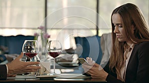 Upset businessman talking with business woman in restaurant