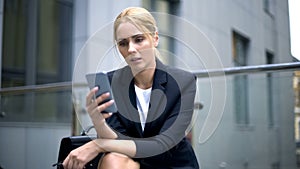 Upset businesswoman reading message about breached contract and dismissal