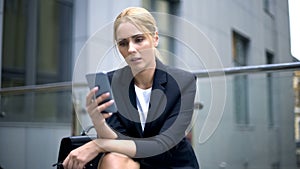 Upset businesswoman reading message about breached contract and dismissal photo