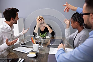 Upset Businesswoman Sitting With Colleague In Meeting