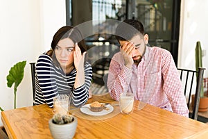 Upset couple arguing at a cafe