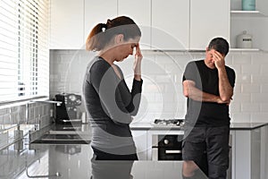 Upset couple contemplating in home kitchen