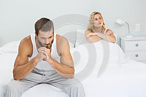 Upset couple ignoring each other after fight on bed