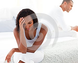 Upset couple sitting on bed separately