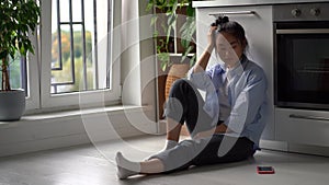 Upset depressed Asian girl suffering from breakup, waiting for call or message from ex boyfriend