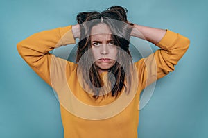 Upset disappointed woman holding head with tousled hair in hands. Depression, family misunderstandings