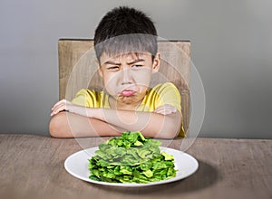 Rovesciato un disgustato ispanico un bambino sul tavolo prima spinaci piatto infelice rifiuto fresco pasto trovare quello disgustoso 