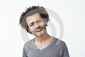 Upset displeased african man looking at camera over white background.